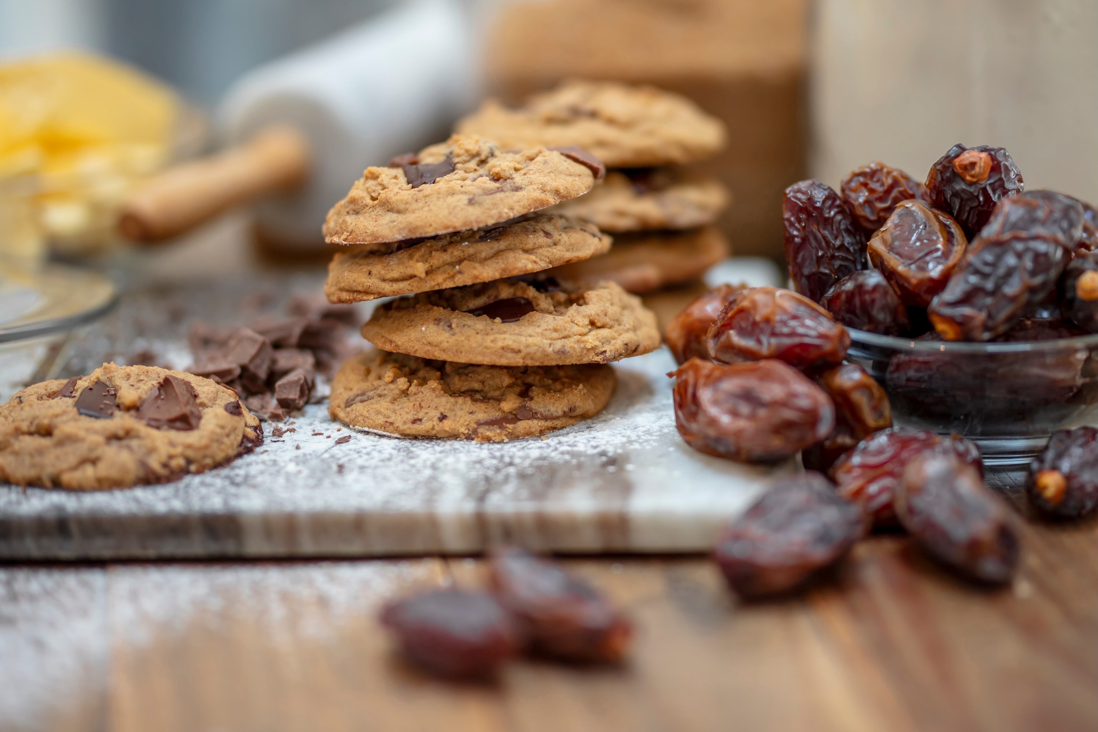 Cookies on wooden board surrounded by ingredients like dates and butter